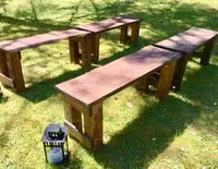 A group of benches in the grass near a lantern.