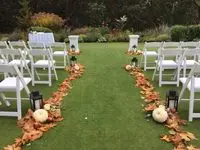 A wedding ceremony with pumpkins and lanterns on the grass.