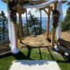 A wedding arch with flowers and a bench