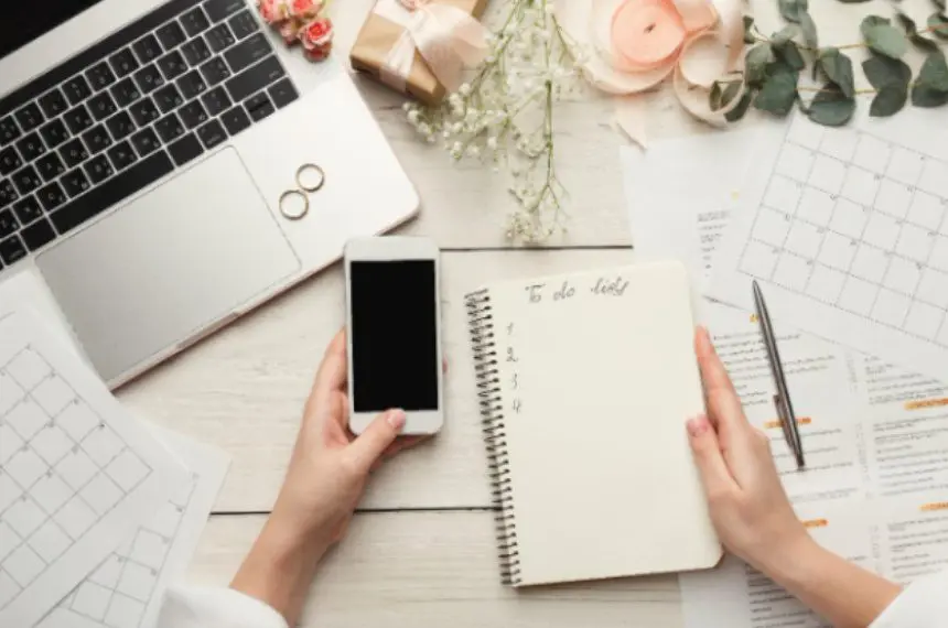 A person holding a phone and a notebook