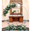 A large round floral arrangement in front of a mirror.