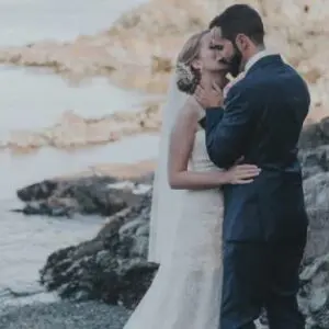 A bride and groom kissing on the beach