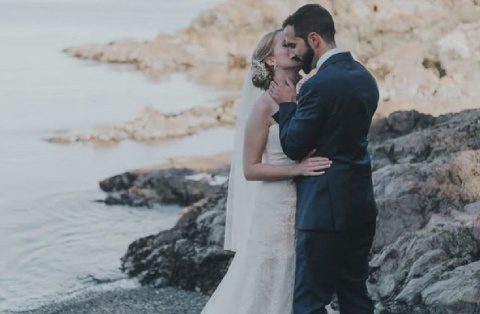 A bride and groom kissing on the beach