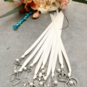 A bouquet of white ribbon with silver charms.