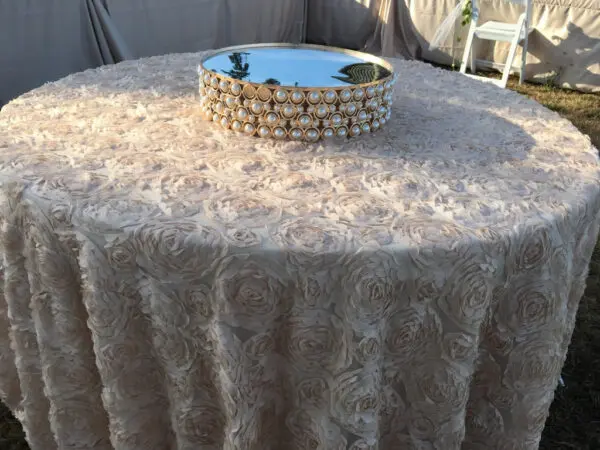 A table with a round cloth and a mirror on top