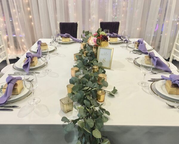 A table set with plates and silverware, candles and flowers.