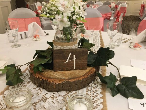 A table with a wooden block and some flowers