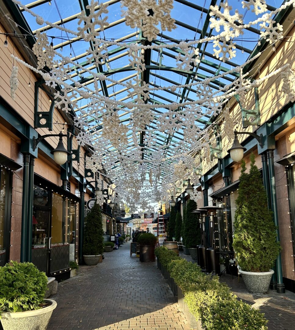 A walkway with lots of glass and flowers.