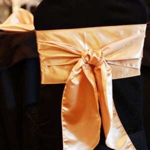 A close up of the back of a chair with a bow on it