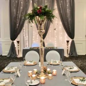 A table set with plates and silverware, candles and flowers.