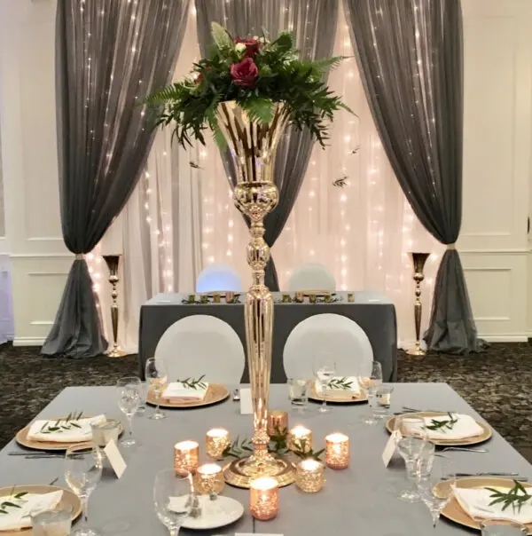 A table set with plates and silverware, candles and flowers.