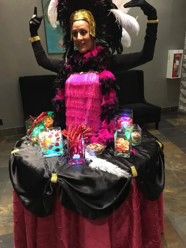 A woman in costume sitting on top of a table.