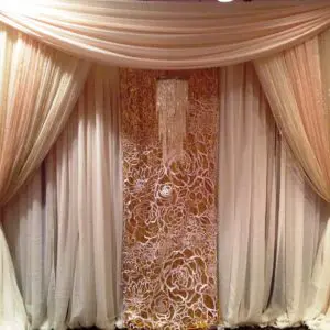 A room with drapes and hay in the center.