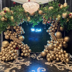 A room with gold balloons and greenery