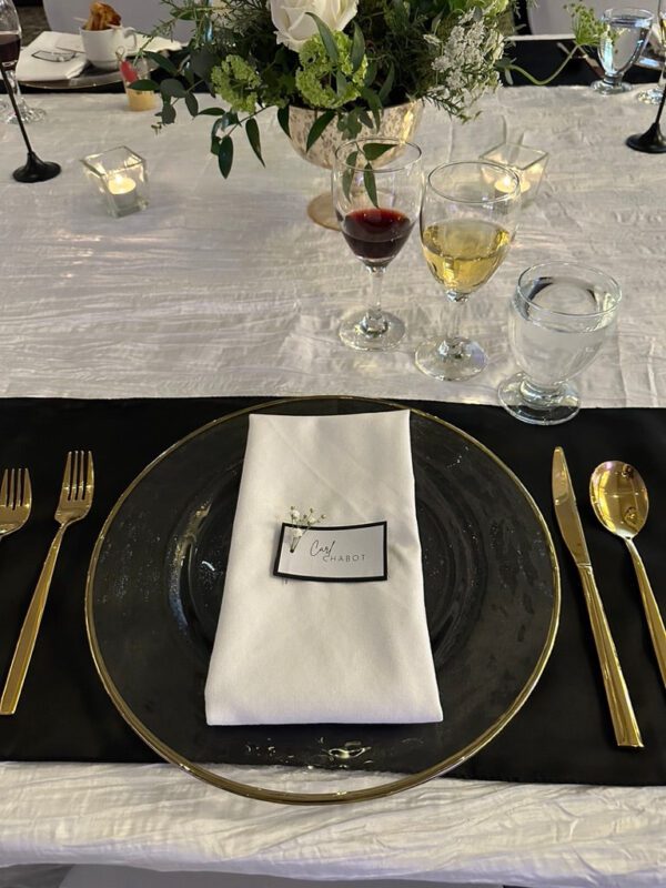 A table set with plates, silverware and wine glasses.