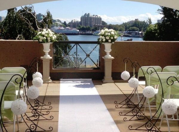 A wedding ceremony with white flowers and a lake view.