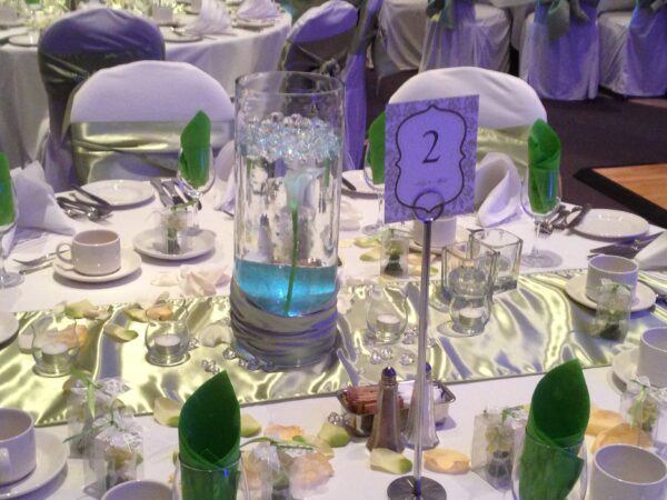 A table set up with purple and green decorations.