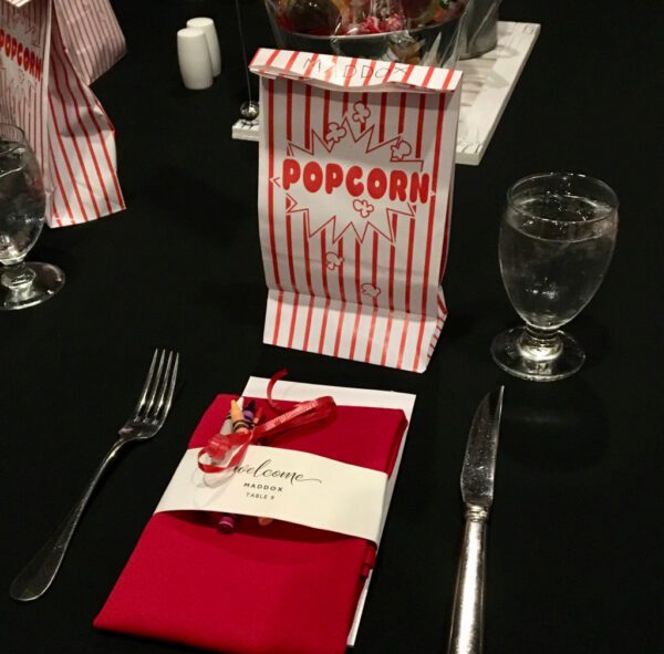 A table set with popcorn bags and silverware.