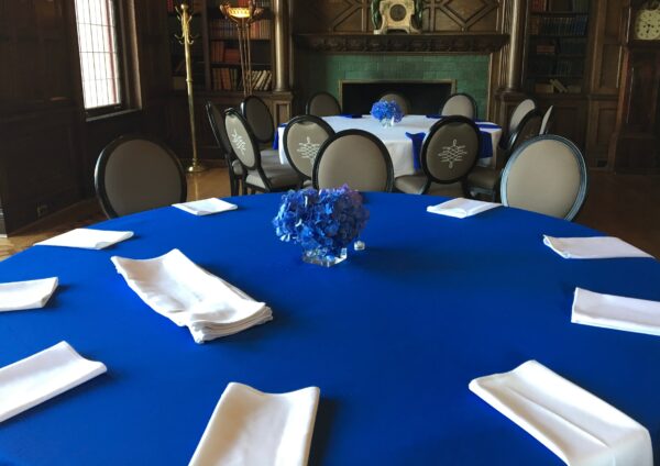 A table with blue cloth and white napkins