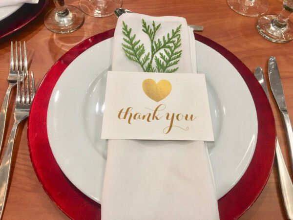 A white plate with a napkin and some red plates