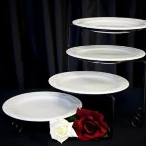 A white plate sitting on top of a black stand.