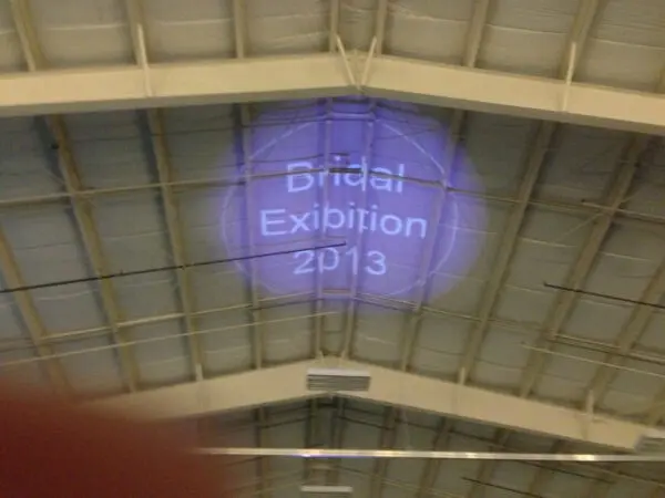 A purple light is projected on the ceiling of a building.