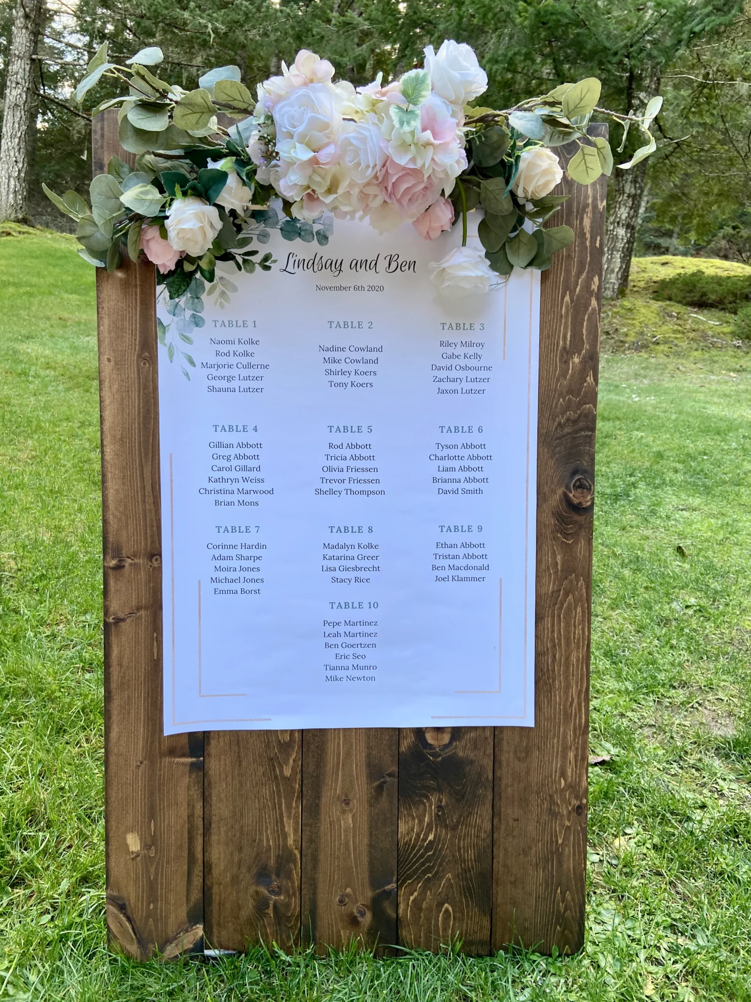 A wooden sign with flowers on it