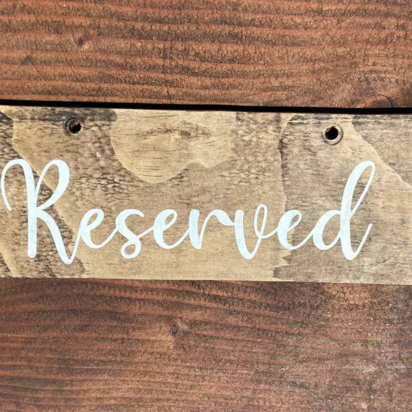 A wooden sign that says reserved on it.