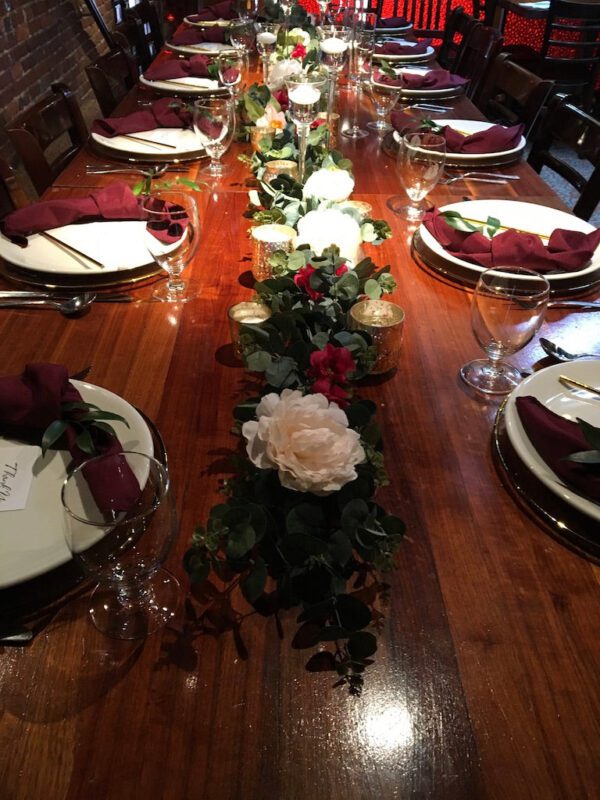 A table set with plates, napkins and flowers.