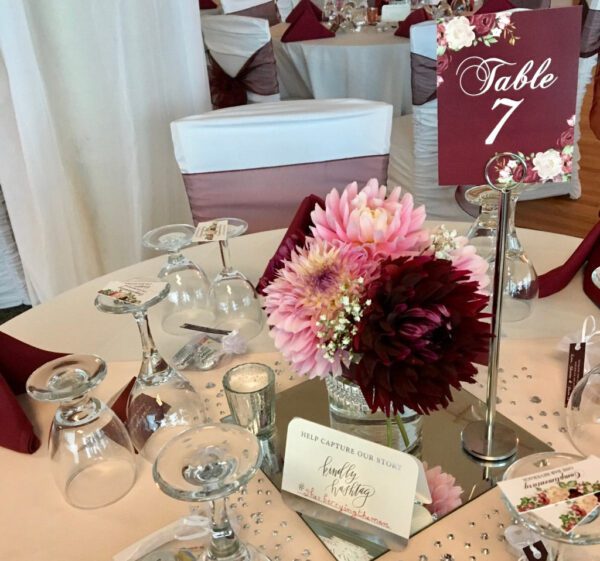 A table set up with flowers and wine glasses.