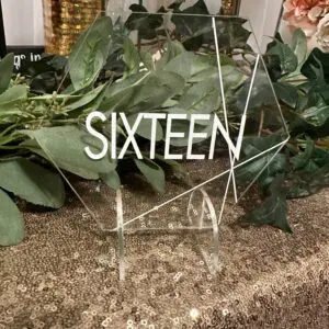 A table with some greenery and a sign