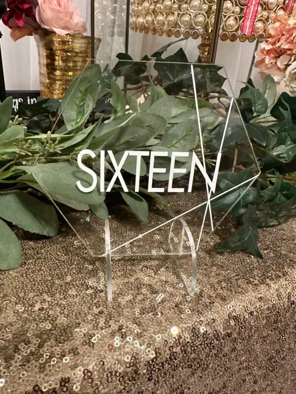 A table with some greenery and a sign