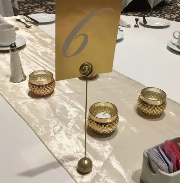 A table with candles and a number six sign.