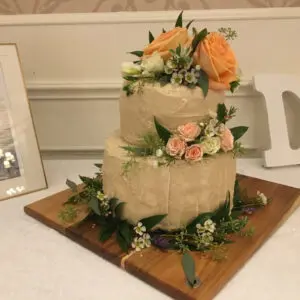 A two layer cake with flowers on top of it.