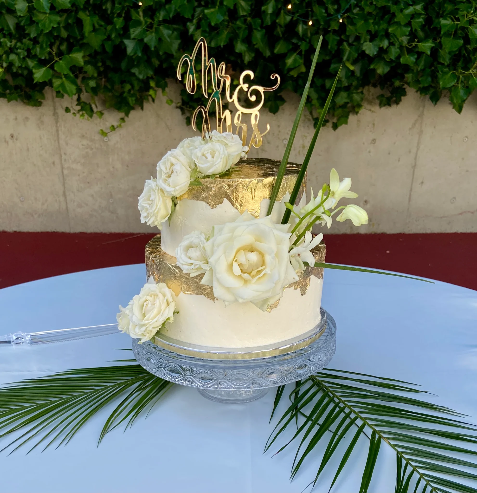 A white and gold cake on top of a table.