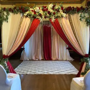 A wedding ceremony with red and white drapes.