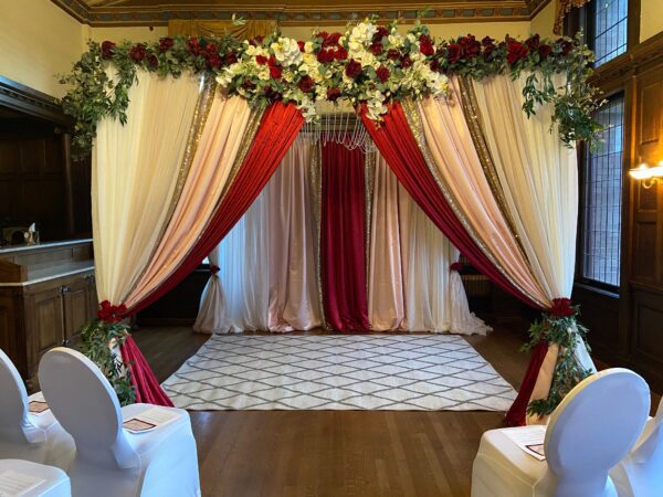 A wedding ceremony with red and white drapes.