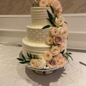 A three tiered cake with flowers on top of it.