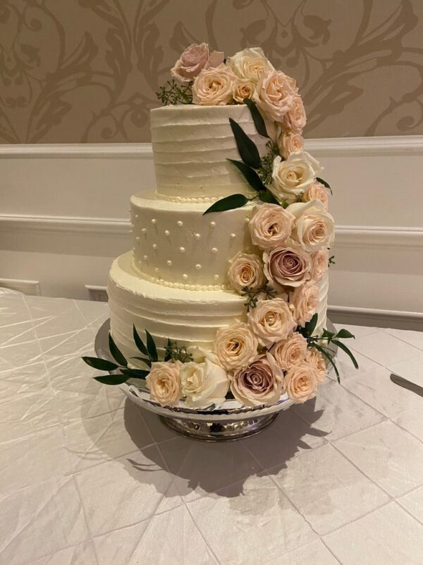 A three tiered cake with flowers on top of it.