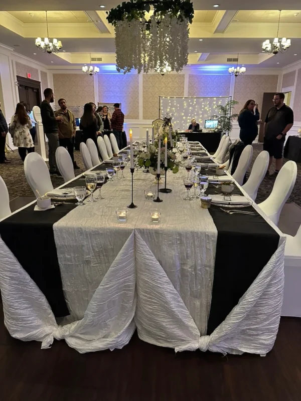 A long table with white and black linens