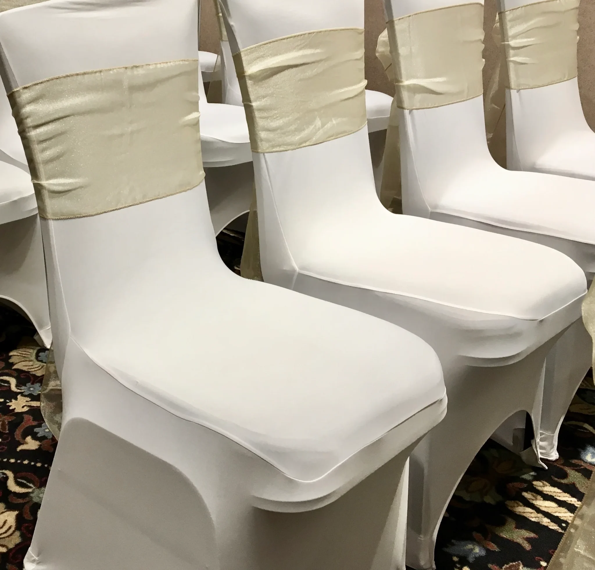 A row of white chairs with beige ties.