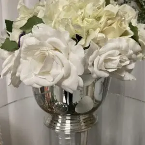 A vase with white flowers in it on top of a table.