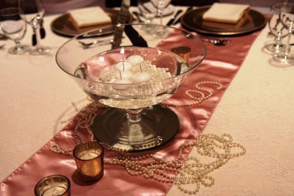 A table set with candles and pearls on it.