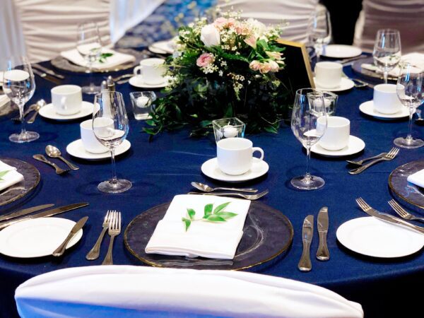 A table set with plates, silverware and napkins.