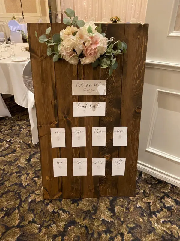 A wooden board with cards and flowers on it