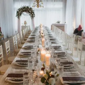 A long table with many plates and candles on it