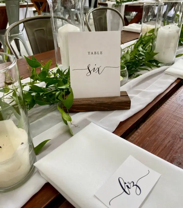 A table set with candles and place cards.