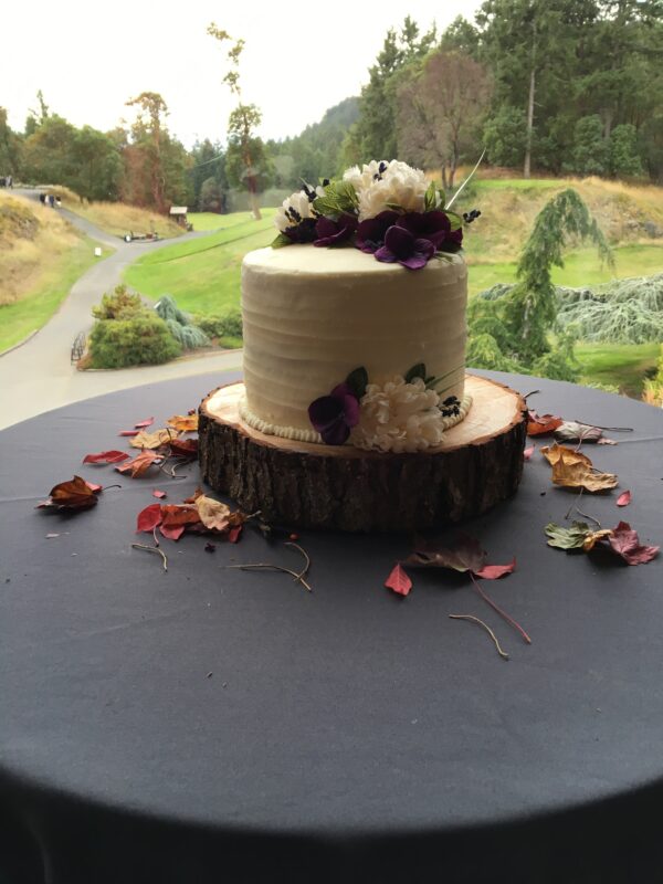 A small cake on top of a wooden stand.