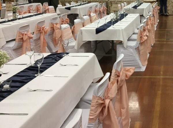 A room filled with tables and chairs covered in white cloth.