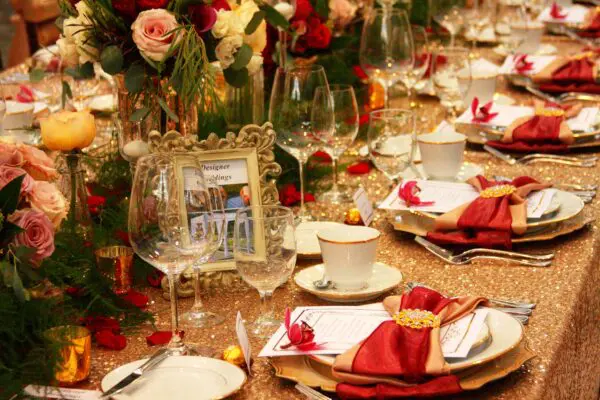 A table set with plates, cups and wine glasses.